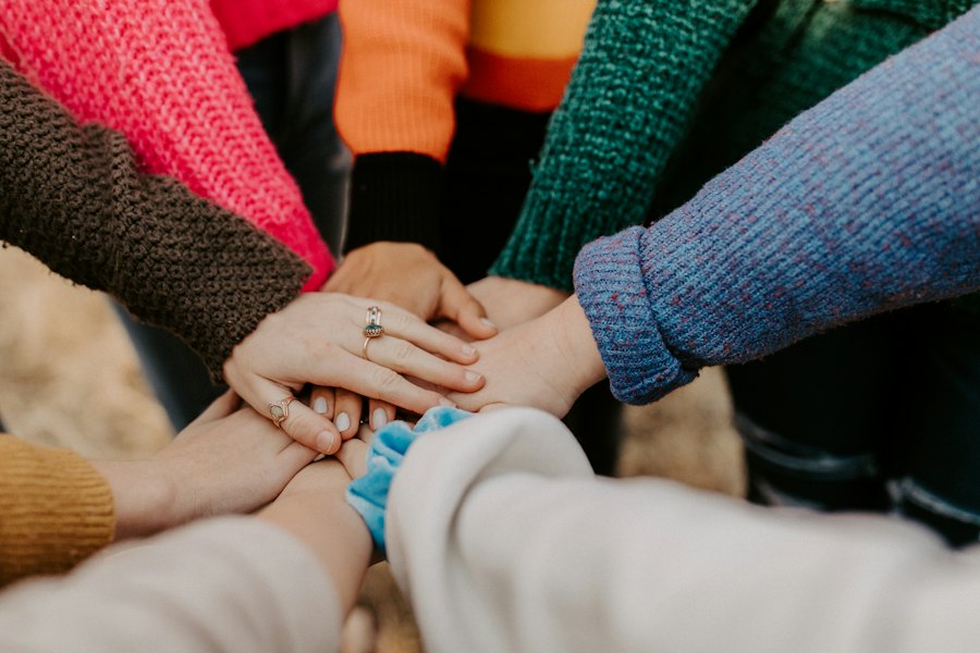 Many hands stacked together in the middle of a circle