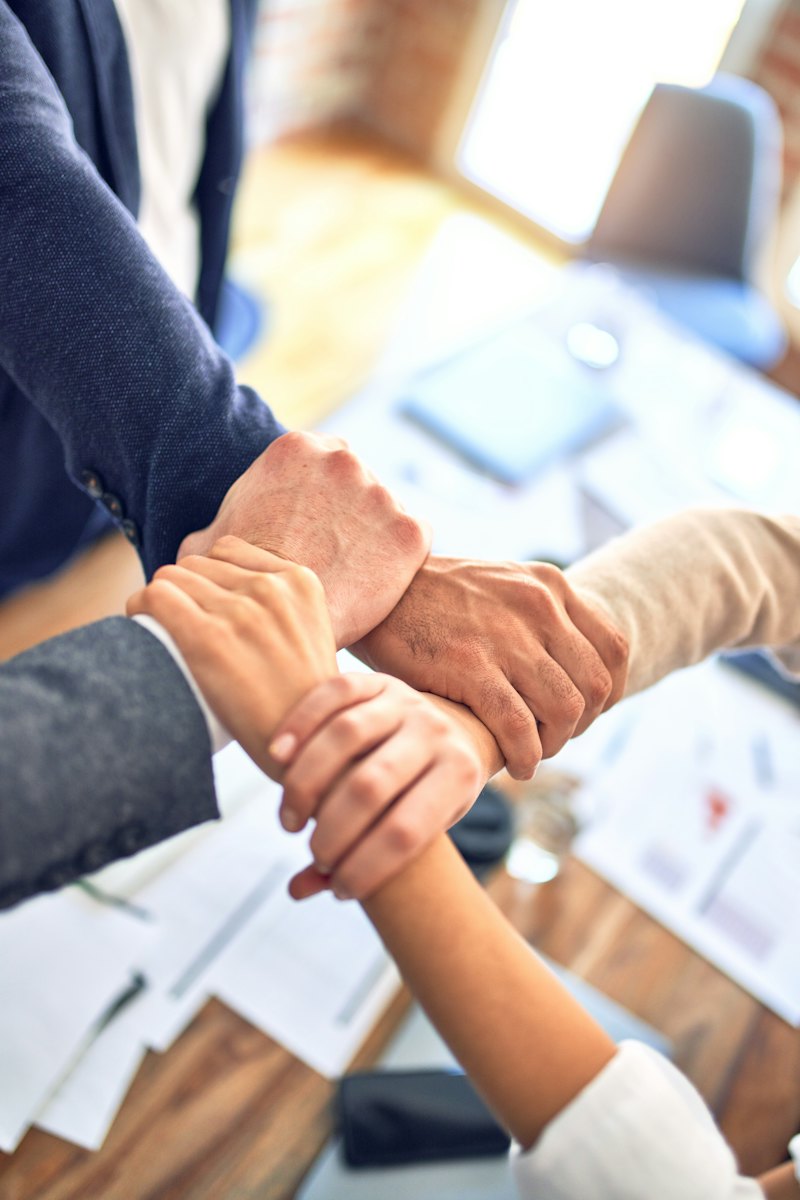 Hands of different skin tones linked together