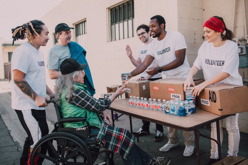 A diverse team of volunteers handing out food and water