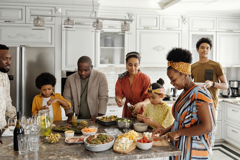 A multigenerational family preparing a meal together in the kitchen
